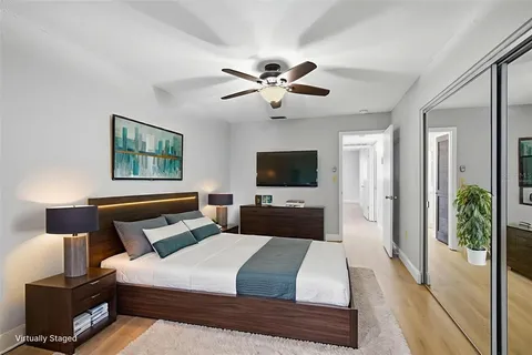 a bedroom with a bed a flat screen tv and a couch