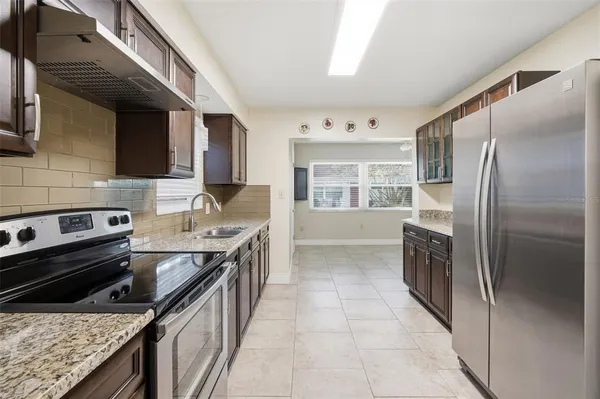 a kitchen with stainless steel appliances granite countertop a sink stove and refrigerator