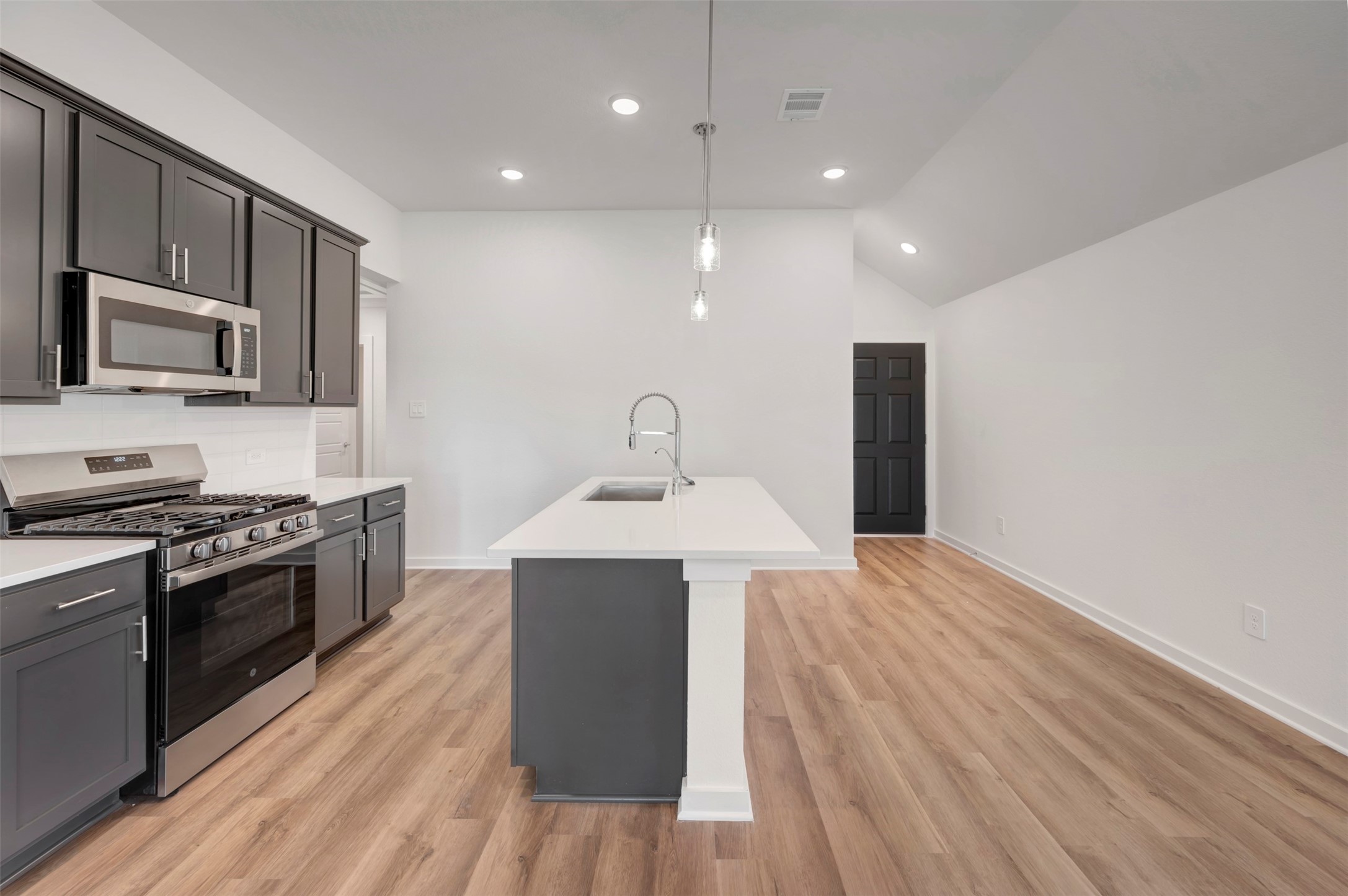 633 Falling Cave Drive Willis, TX 77378 - Photo 15 of 42 a kitchen with kitchen island stainless steel appliances a sink cabinets and wooden floor