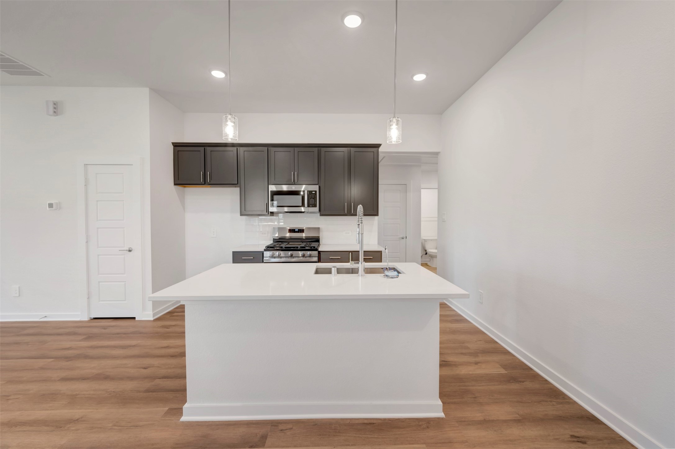 633 Falling Cave Drive Willis, TX 77378 - Photo 17 of 42 a large kitchen with stainless steel appliances a sink a stove and a wooden floors