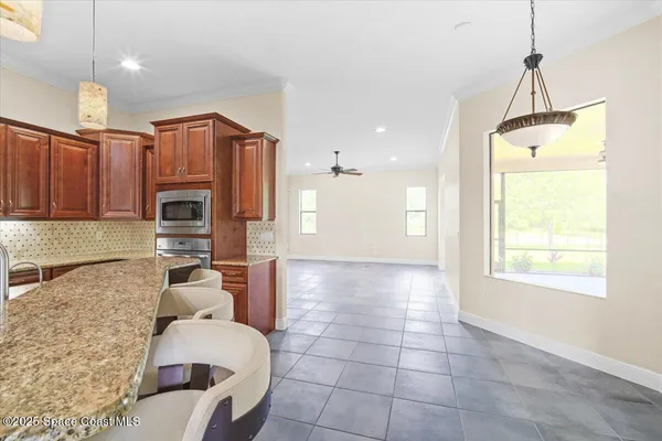 a kitchen with stainless steel appliances granite countertop a sink refrigerator and microwave