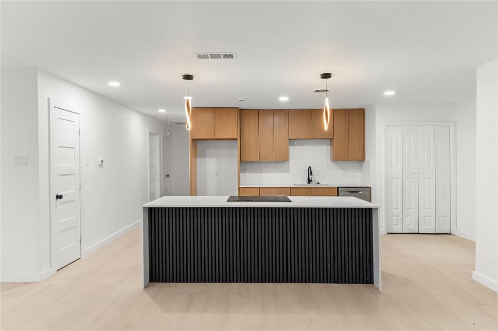 110 Hackberry Street Lancaster, TX 75146 - Photo 2 of 32 Contemporary kitchen island with a slatted black base and light-toned countertop