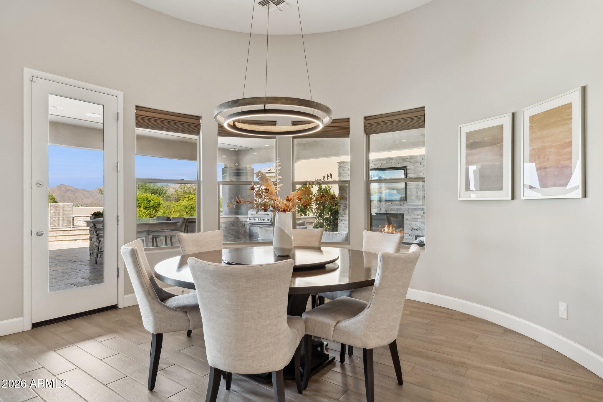 17964 East Wolf Tree Lane Rio Verde, AZ 85263 - Photo 10 of 101 a dining room with furniture a chandelier and wooden floor