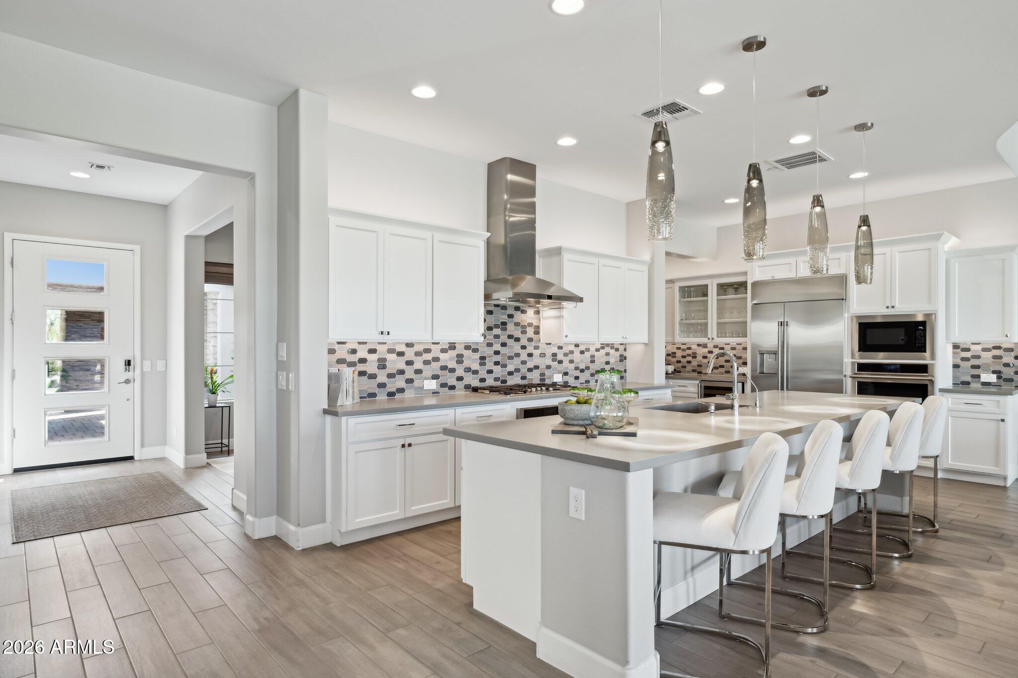 17964 East Wolf Tree Lane Rio Verde, AZ 85263 - Photo 11 of 101 a kitchen with stainless steel appliances kitchen island granite countertop a stove top oven a sink a dining table and chairs