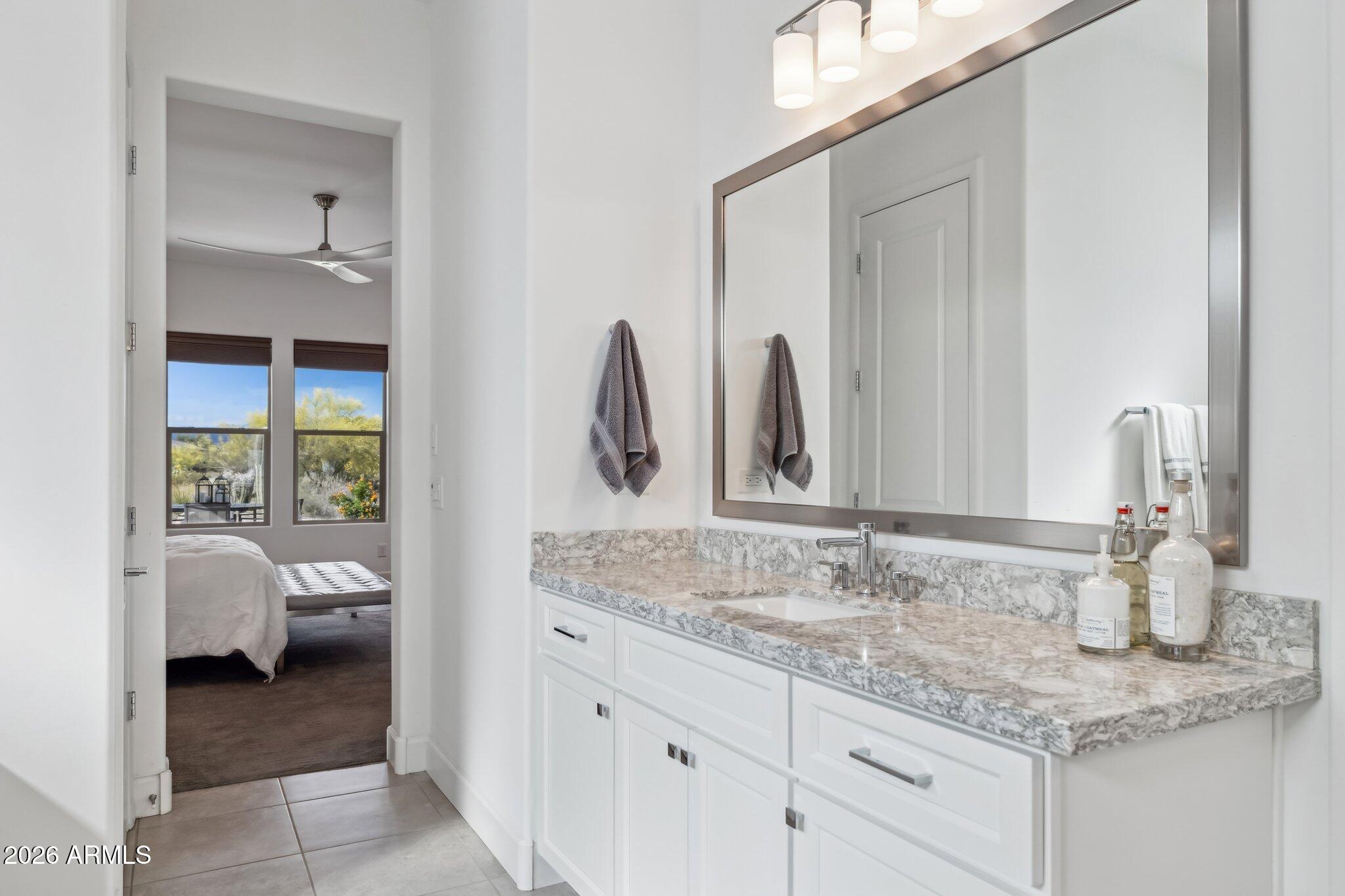 17964 East Wolf Tree Lane Rio Verde, AZ 85263 - Photo 26 of 101 a en suite bathroom with a granite countertop sink and a mirror