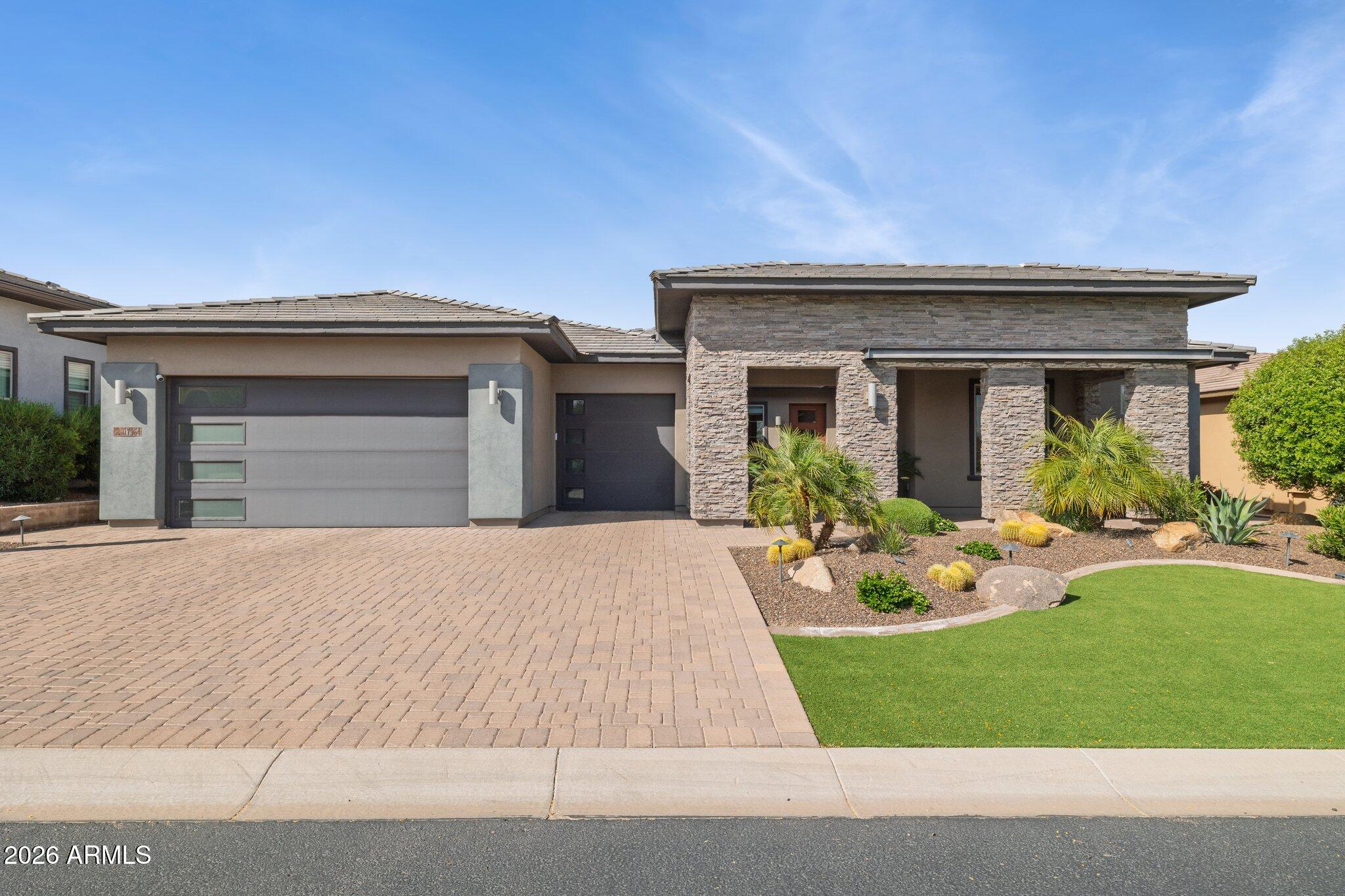 17964 East Wolf Tree Lane Rio Verde, AZ 85263 - Photo 2 of 101 a front view of a house with garden and porch
