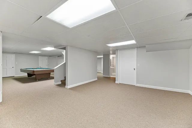 a room with pool table and windows