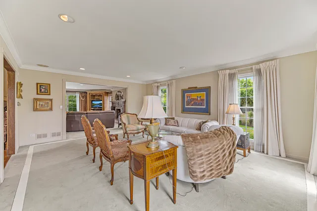 a living room with furniture a large window and wooden floor