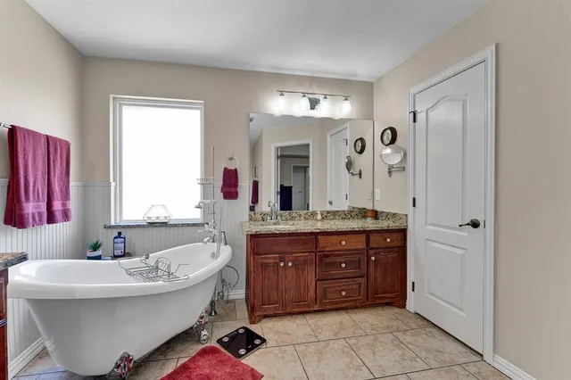 a bathroom with a tub sink and mirror