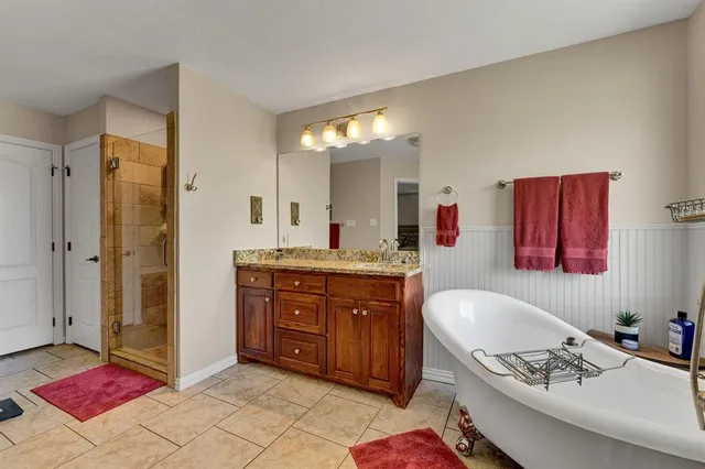 a spacious bedroom with a bed and a flat screen television