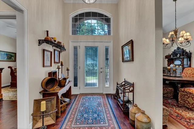 a dining room with furniture a chandelier and wooden floor