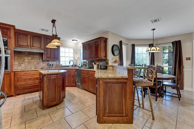 a kitchen with stainless steel appliances granite countertop a stove and cabinets