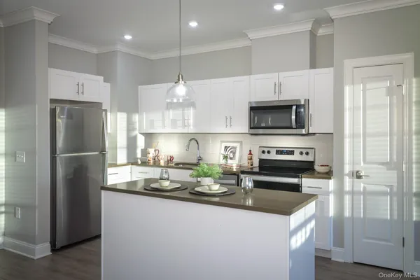 a kitchen with a refrigerator a microwave a sink and cabinets
