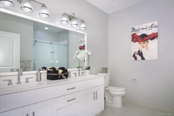 a bathroom with a sink a toilet and a mirror