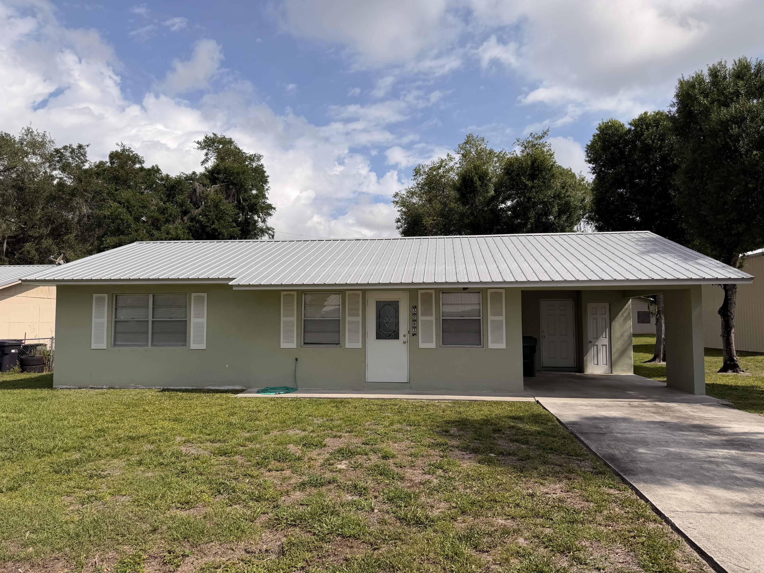 3283 Southwest 20th Street Okeechobee, FL 34974 - Photo 16 of 19 a front view of a house with a garden