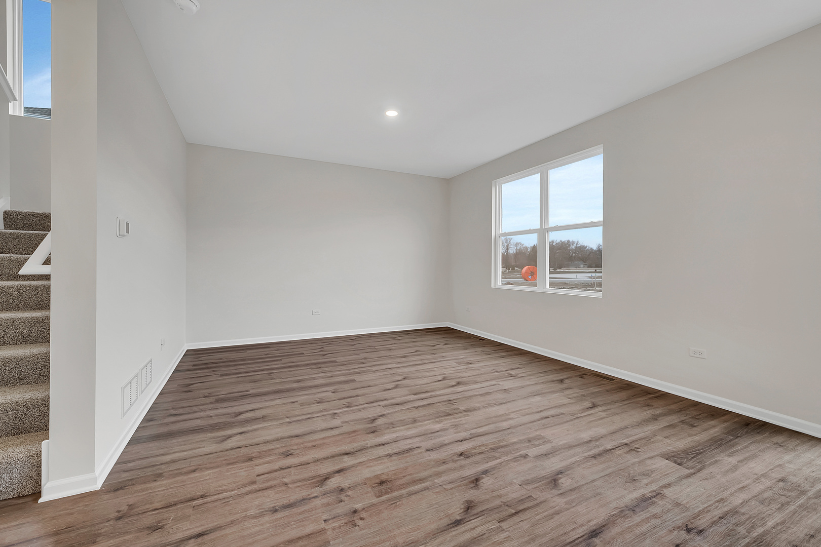 6720 Applegate Drive Plainfield, IL 60586 - Photo 6 of 17 a view of an empty room with wooden floor and a window