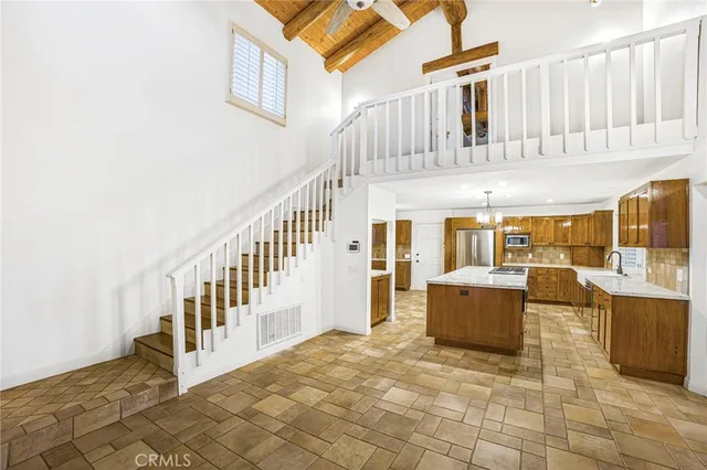 a kitchen with kitchen island a counter top space a sink stainless steel appliances and cabinets