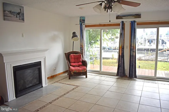 a living room with furniture a fireplace and a floor to ceiling window