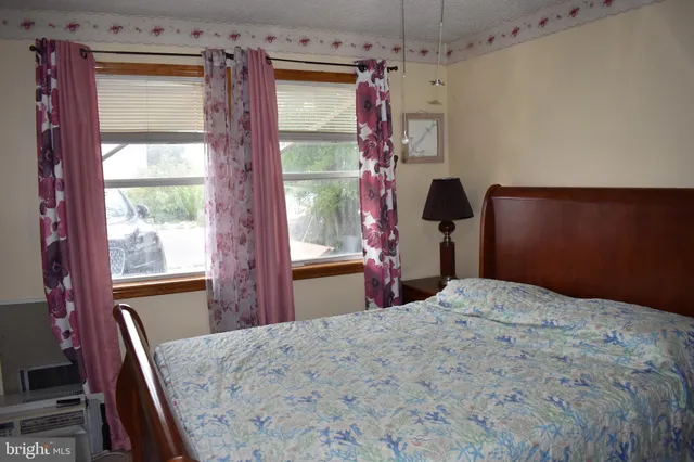 a bedroom with a bed and a dresser next to a window