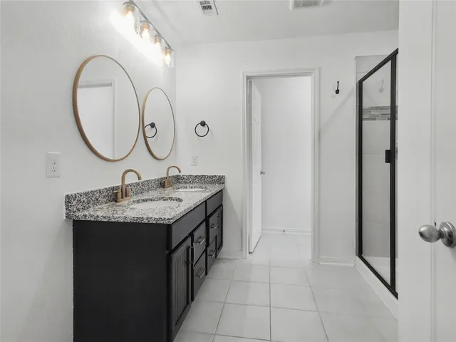 a bathroom with a double vanity sink and a mirror