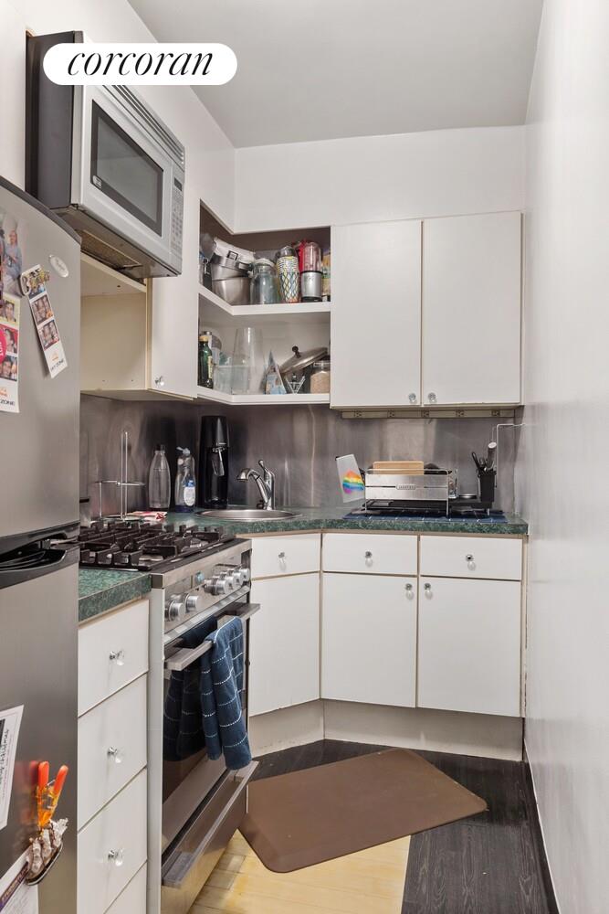 25 West 13th Street, Unit 3FN Manhattan, NY 10011 - Photo 16 of 20 a kitchen with stainless steel appliances granite countertop a stove a sink and a microwave
