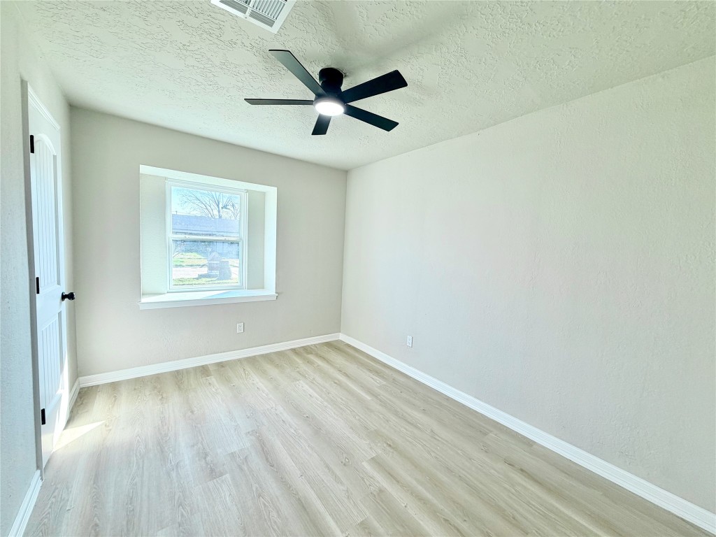 1710 Beaver Bend Road Houston, TX 77088 - Photo 23 of 32 an empty room with wooden floor ceiling fan and window