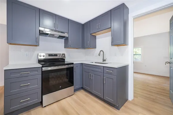 a kitchen with a sink stove and microwave
