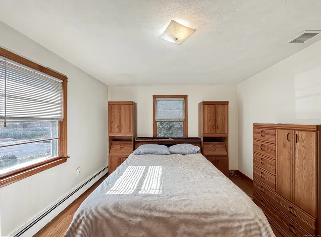 a bedroom with a bed and dresser with mirror