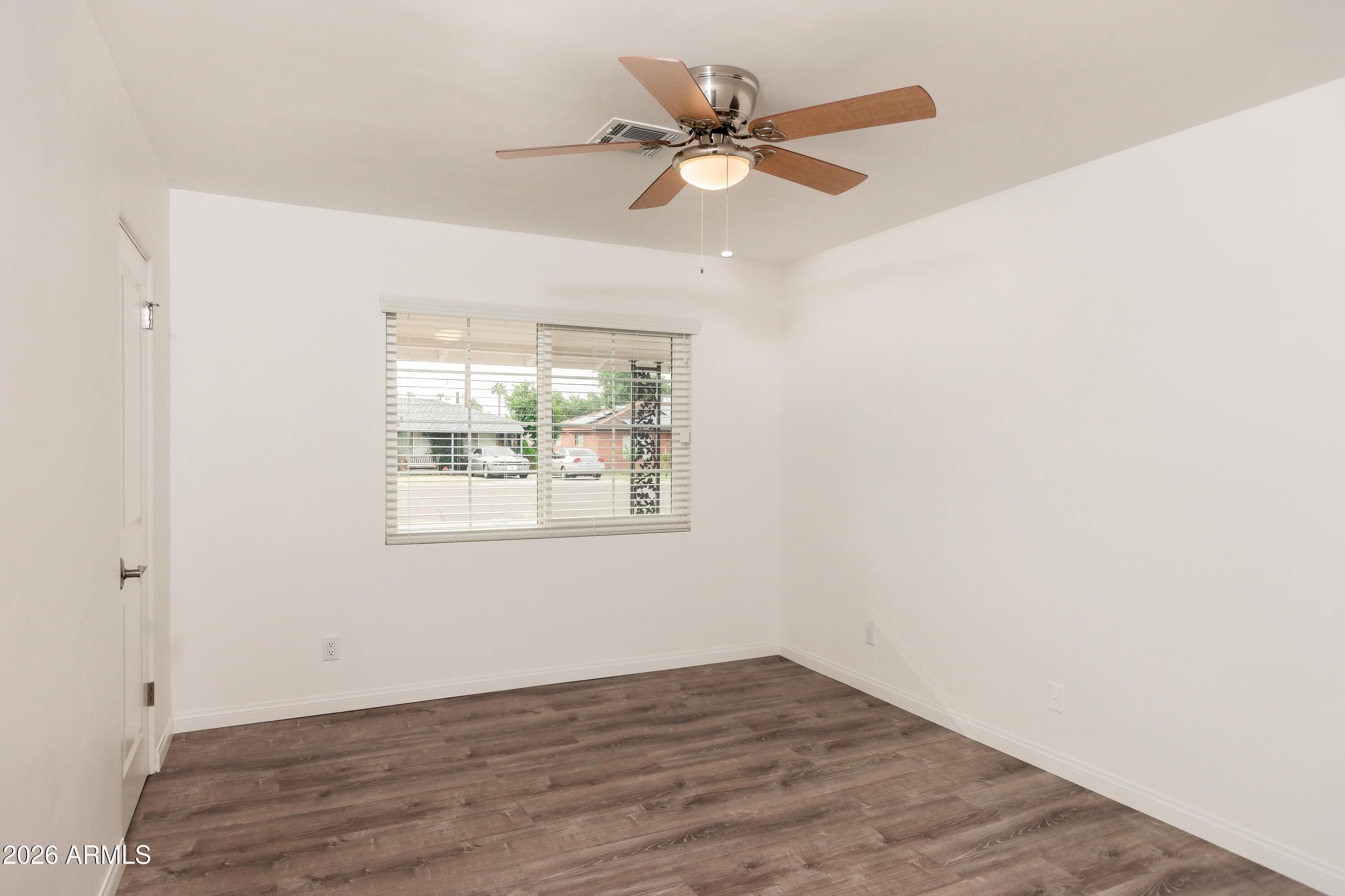 2226 East Devonshire Avenue Phoenix, AZ 85016 - Photo 13 of 17 an empty room with wooden floor fan and windows