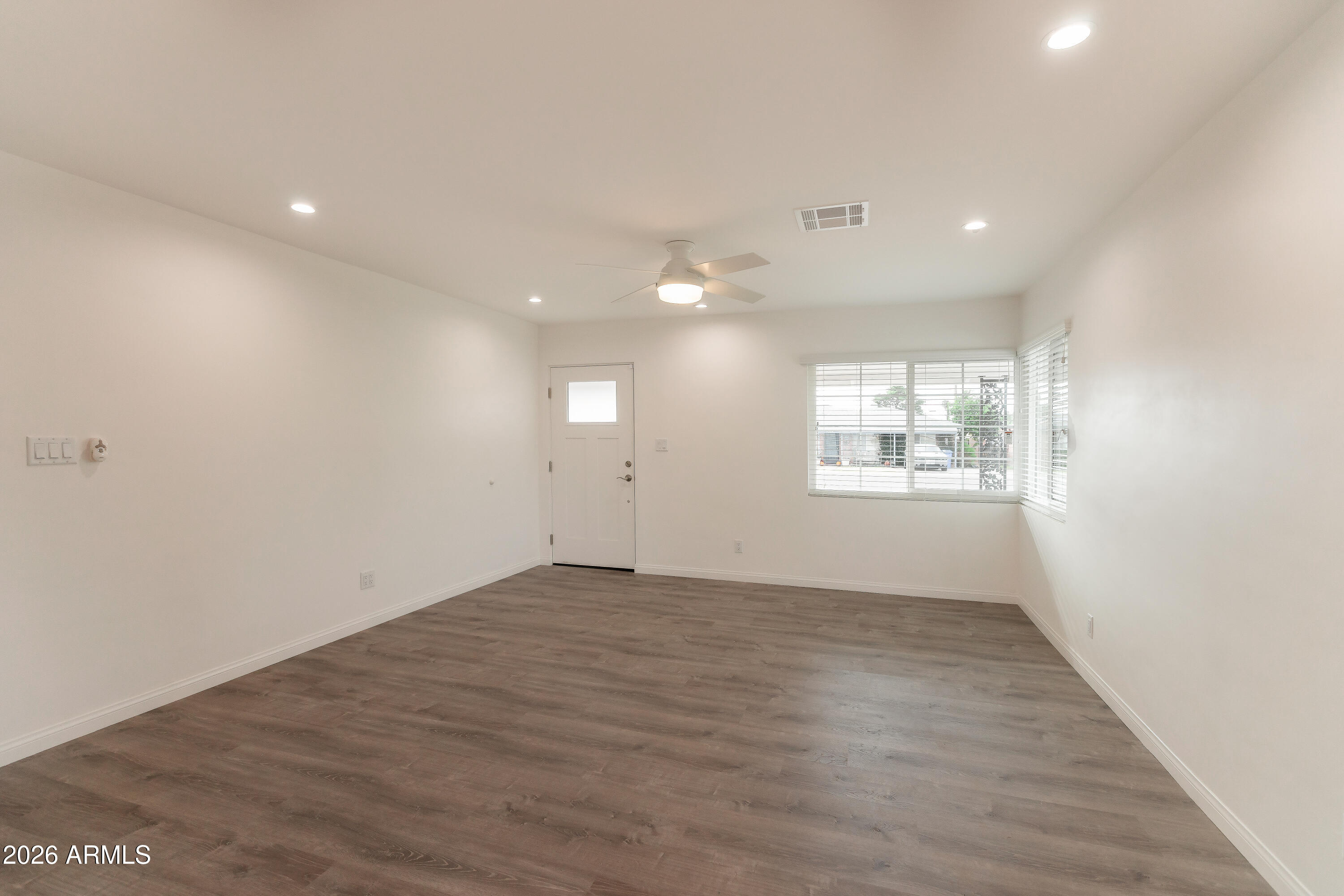 2226 East Devonshire Avenue Phoenix, AZ 85016 - Photo 6 of 17 an empty room with wooden floor and windows