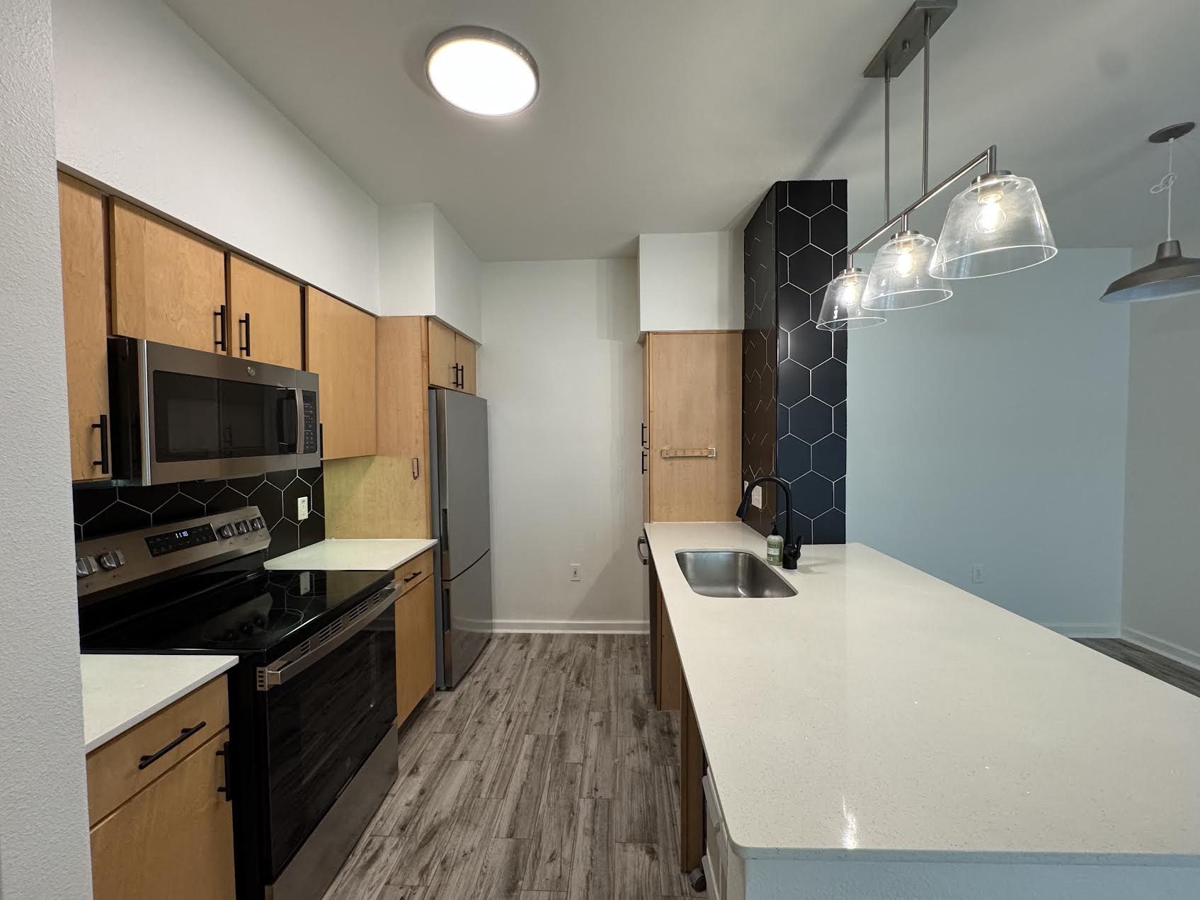 a kitchen with a sink a counter top space stainless steel appliances and cabinets