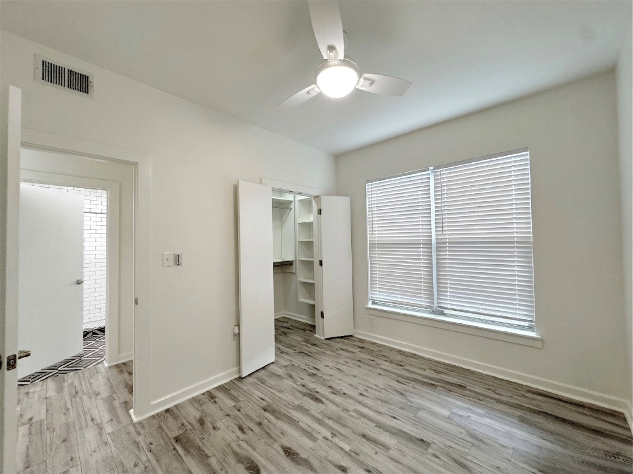 1201 Grove Boulevard, Unit 1701 Austin, TX 78741 - Photo 4 of 10 an empty room with wooden floor cabinet and windows
