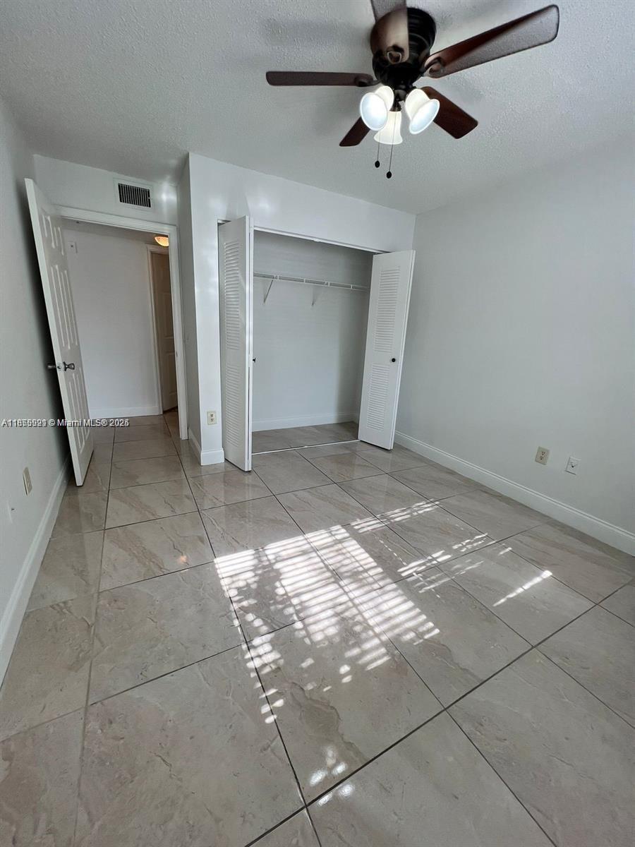 5065 Wiles Road, Unit 103 Coconut Creek, FL 33073 - Photo 13 of 20 a view of an empty room and a ceiling fan window