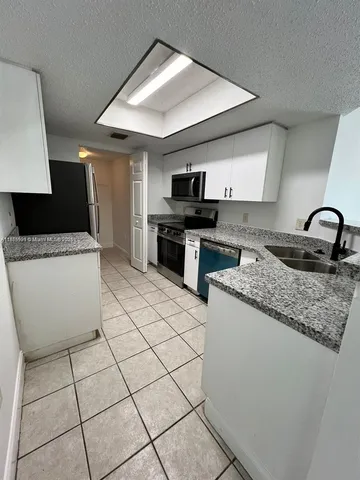 a kitchen with a sink a stove and cabinets