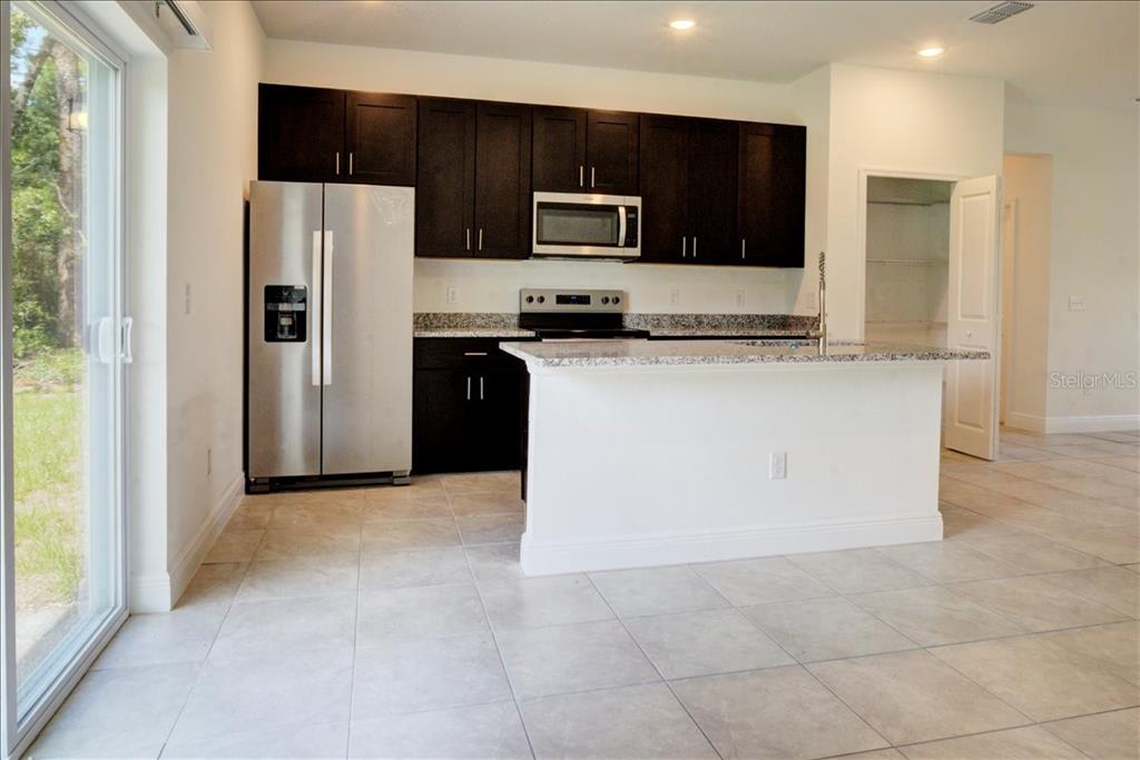 6952 Southwest 152nd Street Ocala, FL 34473 - Photo 5 of 25 a kitchen with stainless steel appliances granite countertop a refrigerator and a stove top oven
