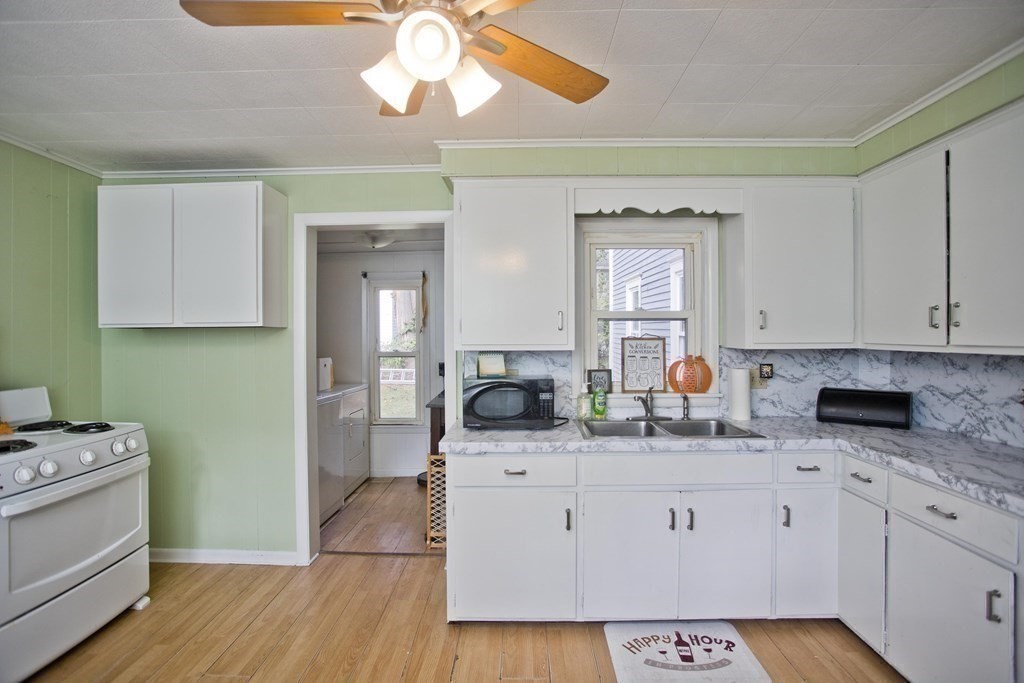 95 School Street Warren, MA 01083 - Photo 15 of 41 a kitchen with a sink dishwasher and white cabinets with wooden floor
