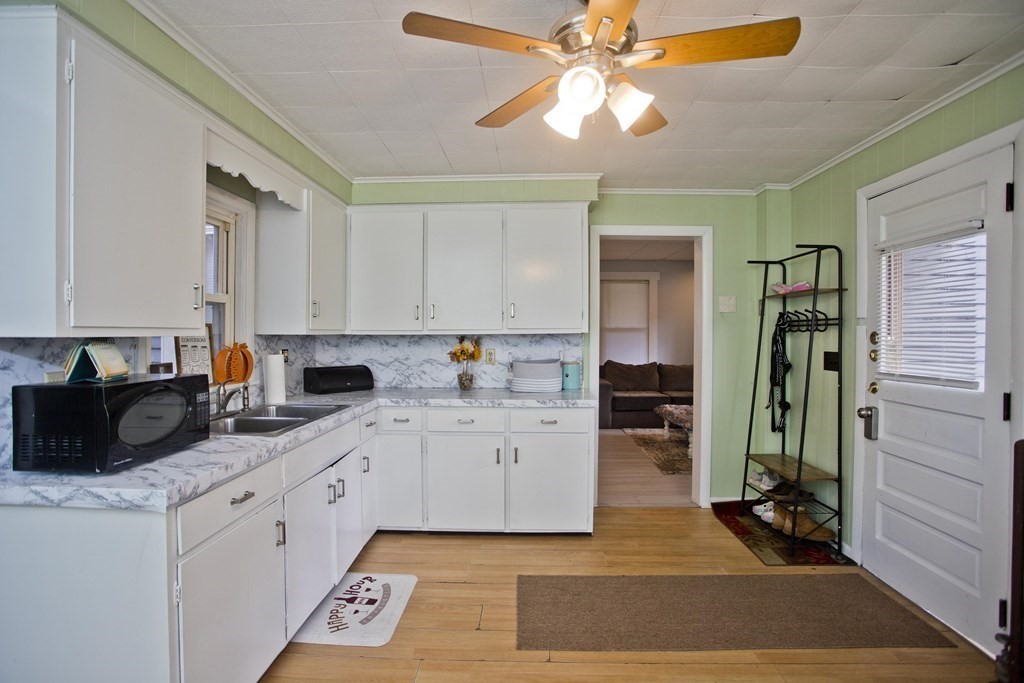 95 School Street Warren, MA 01083 - Photo 3 of 41 a kitchen with a sink dishwasher and white cabinets with wooden floor