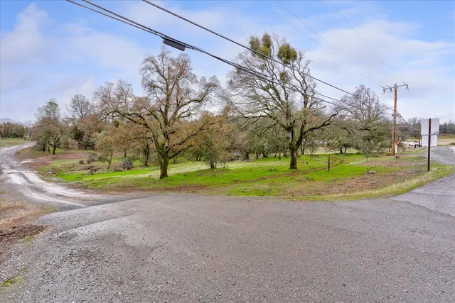 a view of a house with a big yard and large trees