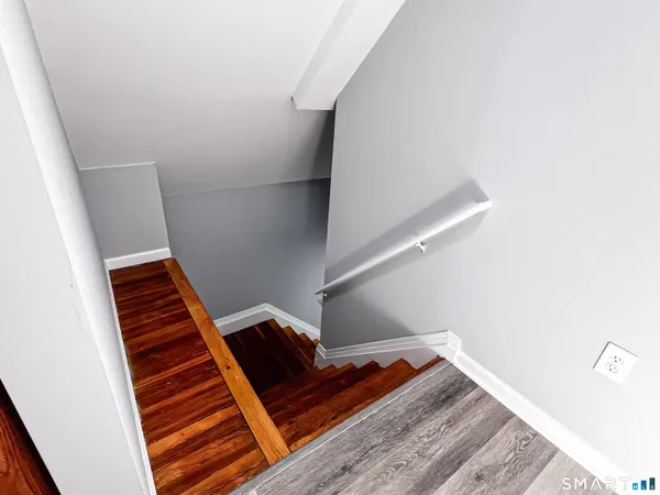 a view of an empty room with wooden floor