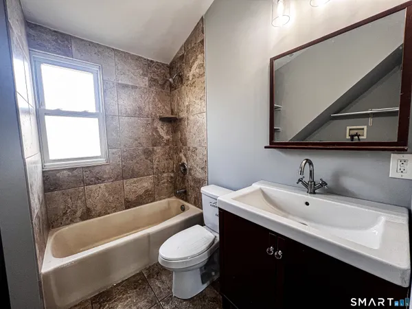 a bathroom with a sink toilet a mirror and bathtub