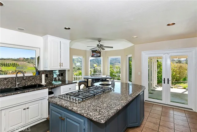 a kitchen with stainless steel appliances granite countertop a kitchen island a stove and a sink