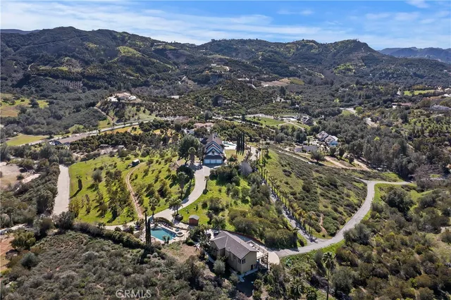 an aerial view of a house with a mountain