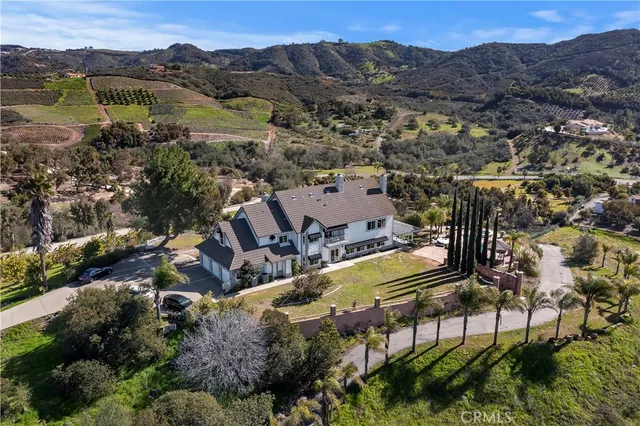 an aerial view of a house with a mountain