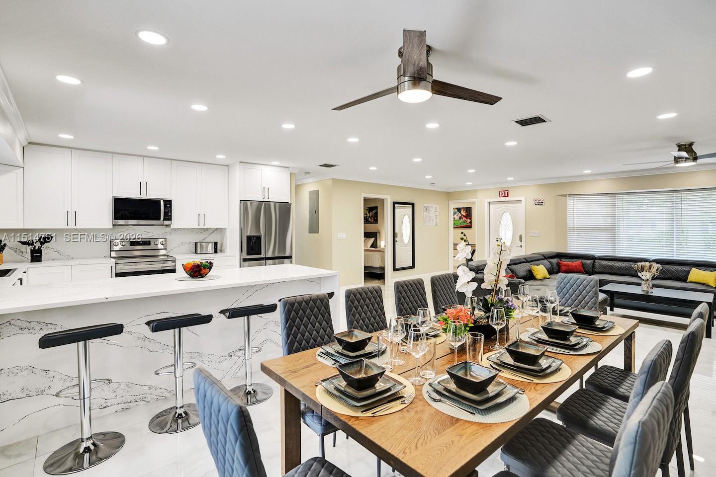 5500 Cleveland Street Hollywood, FL 33021 - Photo 12 of 45 a kitchen with a dining table chairs stove and white cabinets