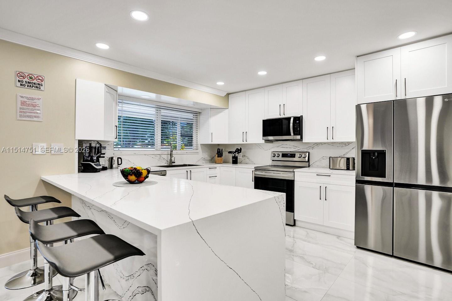 5500 Cleveland Street Hollywood, FL 33021 - Photo 13 of 45 a kitchen with stainless steel appliances a stove refrigerator sink microwave and cabinets