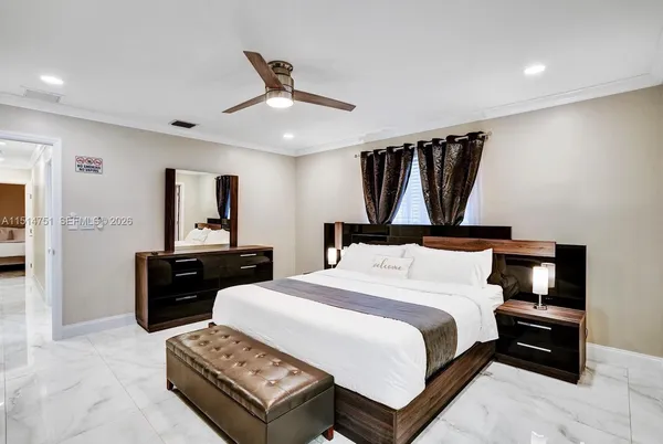 a bedroom with a bed a mirror and a window