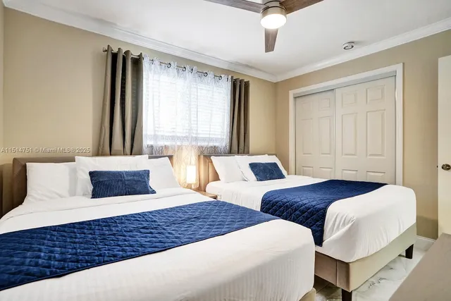 a view of a bedroom with two beds and a painting on the wall