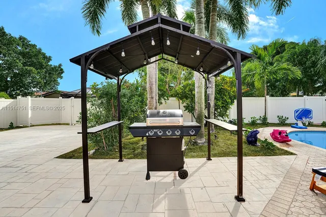 a view of a patio with table and chairs potted plants with palm trees