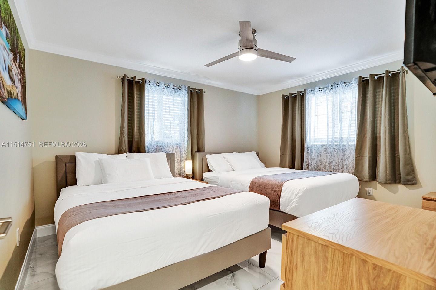 5500 Cleveland Street Hollywood, FL 33021 - Photo 42 of 45 a bedroom with two beds and a chandelier