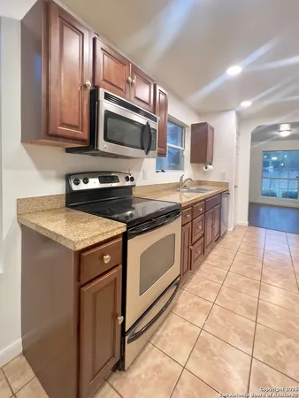 a kitchen with stainless steel appliances granite countertop a stove a sink and a microwave
